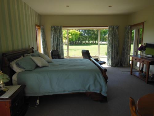 a bedroom with a bed and a large window at Lincoln Country Dream in Lincoln