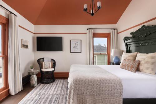 a bedroom with a bed and a flat screen tv at Centrella Hotel, a Kirkwood Collection Hotel in Pacific Grove