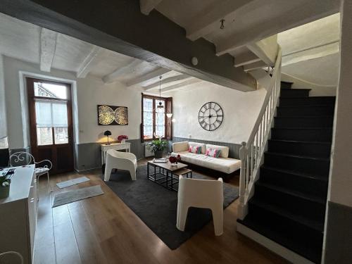un salon avec un canapé et un escalier dans l'établissement Maison de charme à Barrou, proche La Roche-Posay, cour, lave-linge, lave-vaisselle, WIFI, animaux OK - FR-1-541-110, à Barrou