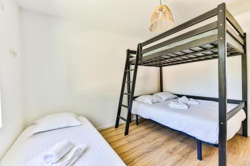 Ce lit se trouve dans un dortoir doté de 2 lits superposés, de murs blancs et de parquet. dans l'établissement Agréable maison neuve avec spa, à Saint-Hilaire-de-Riez