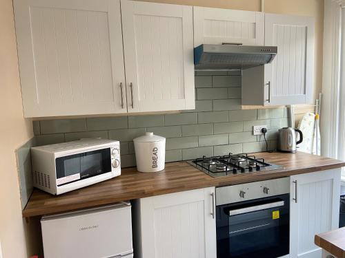 a kitchen with a microwave and a stove top oven at Marina Holiday Apartments in Bridlington