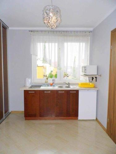 a kitchen with a sink and a window at Dom Wczasowy Adela in Łeba