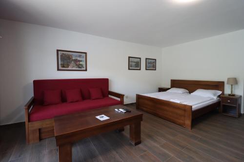 a room with a bed and a couch and a table at Dunavska Vila Milosavljevic in Donji Milanovac