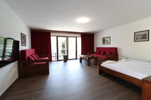 a hotel room with a bed and two red chairs at Dunavska Vila Milosavljevic in Donji Milanovac