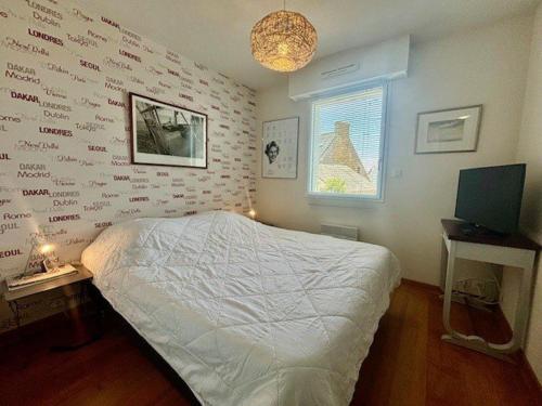 - une chambre dotée d'un lit et d'un mur avec écriture dans l'établissement Appartement 2P à Quiberon, 43m², Balcon, Parking, Wifi, 3 étoiles, Proche Plage et Centre-Ville - FR-1-478-143, à Quiberon