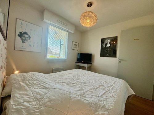 a bedroom with a white bed and a window at Quiberon : 2 pièces confortables avec Wifi et parking proche plage - FR-1-478-143 in Quiberon