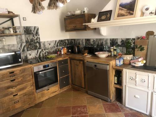 a kitchen with wooden cabinets and a stove top oven at hebergement chez l'habitant Hyères Campagne in Hyères