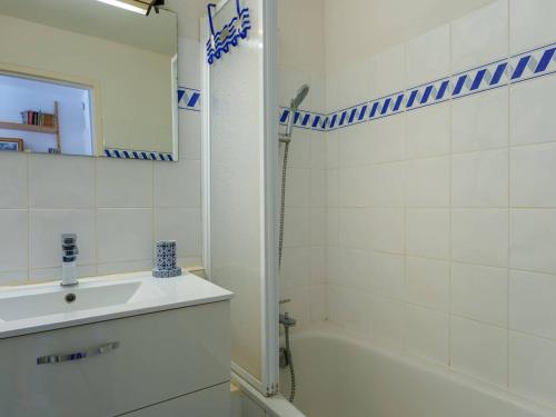 une salle de bain blanche avec une douche et un lavabo dans l'établissement Appartement 2P à 500m des plages, balcon S-O, parking privé, 3* Meublé de Tourisme - FR-1-477-177, à Carnac