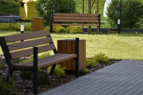 two park benches sitting next to a field of grass at Czartoryskich 7 - 3 pok - parking podziemny w cenie !!! in Puławy