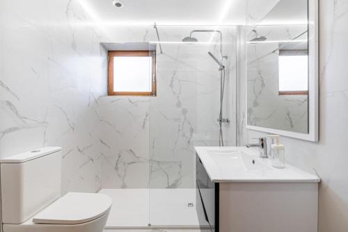 a white bathroom with a shower and a sink at Casa do Fijogo no Gerês avec Piscine in Rio Caldo