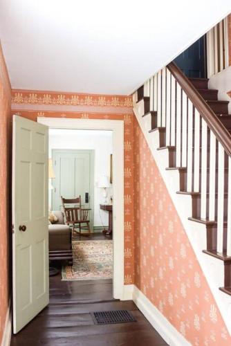 a hallway with a staircase and a living room at The Dutton Farmhouse in Dummerston Center