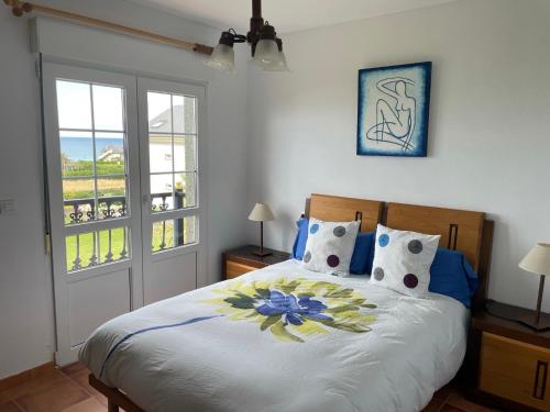 a bedroom with a large bed with blue and yellow pillows at Casa Playa Fontela in San Pedro de Benquerencia