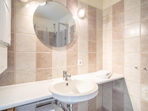 a bathroom with a sink and a mirror at Ferienhaussiedlung Strandperlen Buchenhof 1c (Haustyp II) in Wustrow