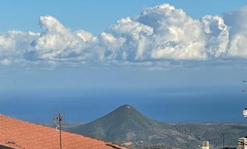a view of a mountain with clouds in the sky at Barighouse in Ulassai