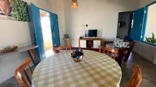 a dining room table with a vase on top of it at Pousada Vila Lua Bela in Pitimbu