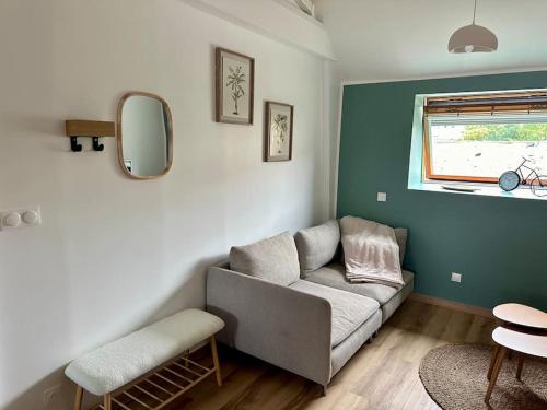 un salon avec un canapé et une fenêtre dans l'établissement Le loft Émeraude, à Dunkerque