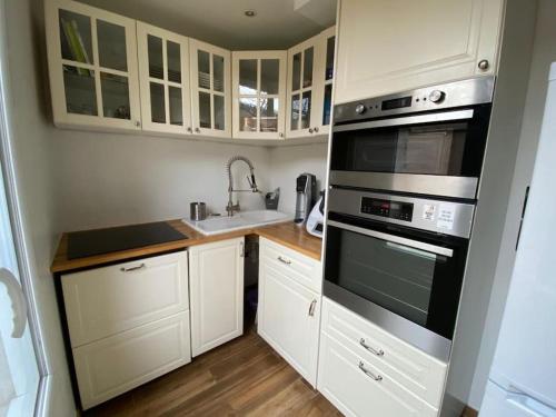 une petite cuisine avec des armoires blanches et un évier dans l'établissement Appartement à Bagneux, à Bagneux