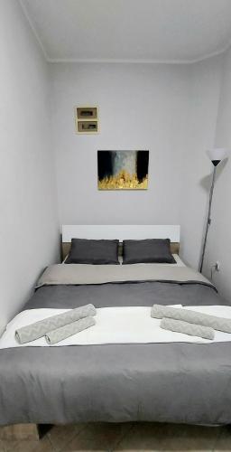 a bedroom with a large bed with two pillows at Apartman SPLENDID in Kladovo