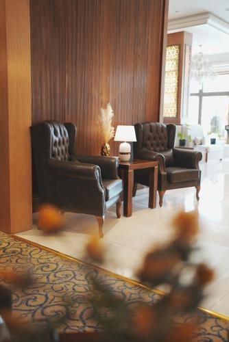 a living room with two chairs and a table at Thousand Nights Hotel Amman - فندق ثاوزند نايتس عمان in Amman