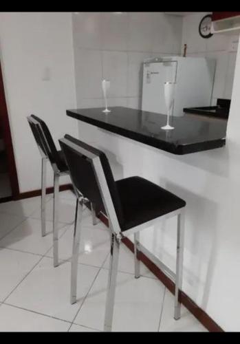 Dos sillas y una mesa con encimera negra. en Casa da árvore, en Río de Janeiro