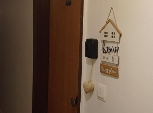 a door with a phone and a house on the wall at Annie's sweet home Paralio Astros in Paralion astros