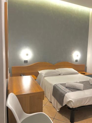 a bedroom with a bed and a desk and a chair at Hotel Sara in Milan