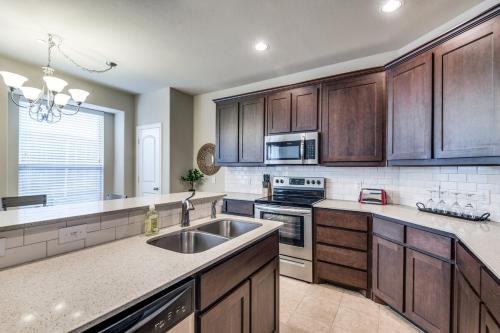 a large kitchen with wooden cabinets and a sink at Irving Bliss in Irving