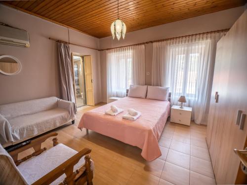 a bedroom with a bed and a couch at Traditional Stone Villa 1 in Ellinikón