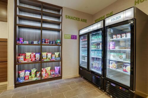 a grocery store aisle with two refrigerators and food at Home2 Suites By Hilton Sanford in Sanford