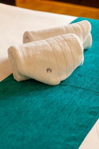 a roll of toilet paper sitting on a bed at Garden Plaza in San Miguel de Tucumán