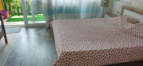 a bedroom with a bed with a red and white comforter at Marko Apartments in Struga