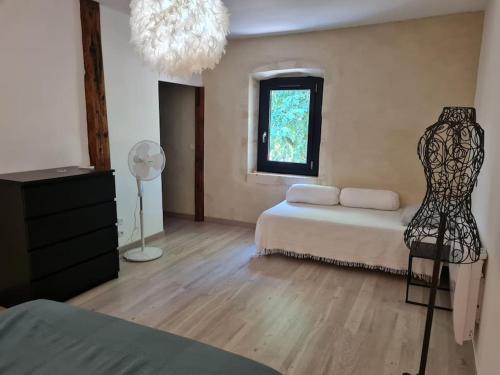 - une chambre avec un lit, une fenêtre et une commode dans l'établissement Partie de mas en campagne, à Eyragues