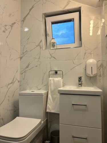 a white bathroom with a toilet and a sink at Casa Zen in Ivanec