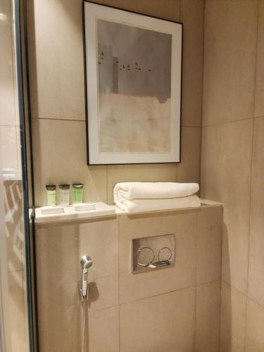 a bathroom with a towel and a picture on the wall at Apartment at Address Beach Resort Sharm Al Aqah in Fujairah