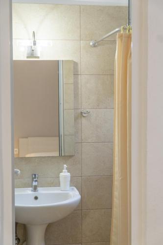 a bathroom with a sink and a mirror at Koks’ Guesthouse in Himare