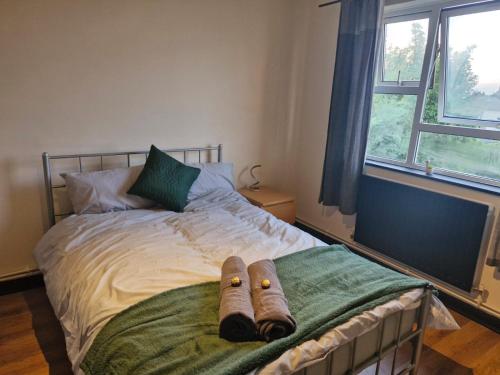 a bed with two pairs of slippers sitting on it at Elegant & Spacious 2-Bedroom Apartment in Wimbledon in London