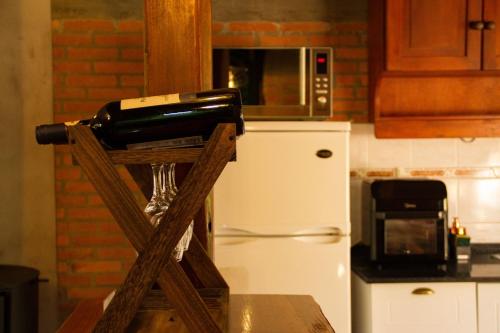 a wine bottle on a wooden stand in a kitchen at Cabañas DELUXE DUNAS DEL ESTE in Punta Colorada