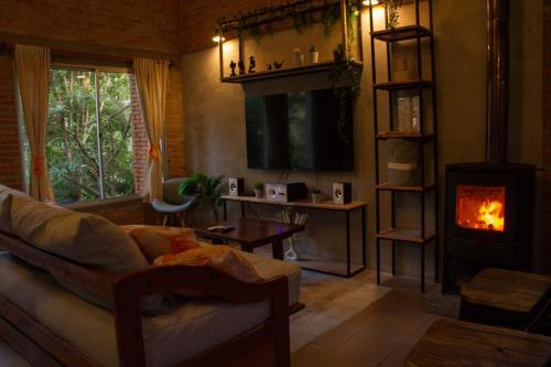a living room with a couch and a fireplace at Cabañas DELUXE DUNAS DEL ESTE in Punta Colorada