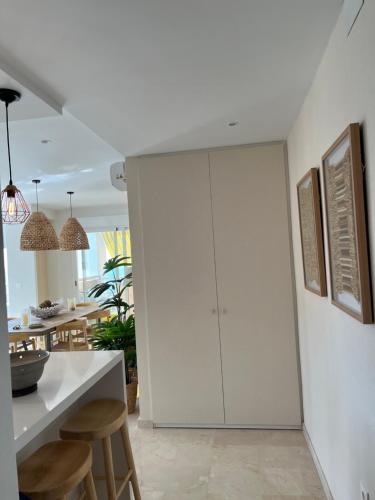 a kitchen with white cabinets and a table and chairs at Ático Solymar in Almuñécar