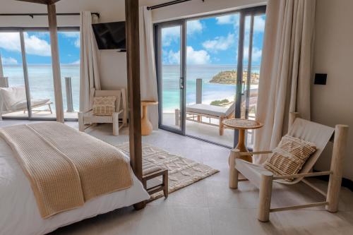 a bedroom with a bed and a view of the ocean at Tamarind Hills Resort & Villas in Johnsons Point