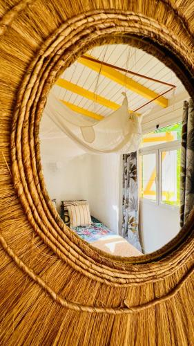 a bedroom with a bed and a round mirror at Île tropical lodges in Sainte-Anne
