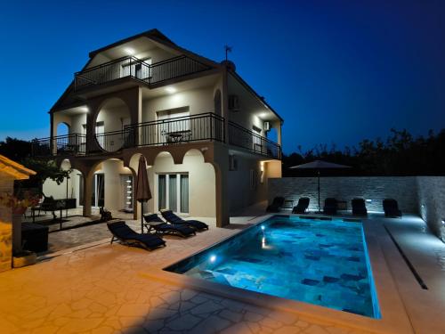 une villa avec piscine la nuit dans l'établissement Villa Marta, à Mala Čista