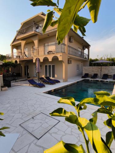 a villa with a swimming pool in front of a building at Villa Marta in Mala Čista