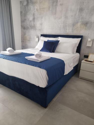 a large bed with blue and white sheets and pillows at Villa Klara in Privlaka