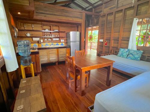 a room with a table and a kitchen with a refrigerator at Casa Viva Eco Lodge in Puerto Viejo