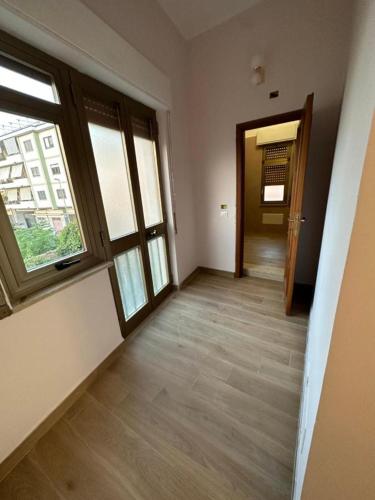 an empty room with a hallway with two windows at B&B Elegance in Villa San Giovanni