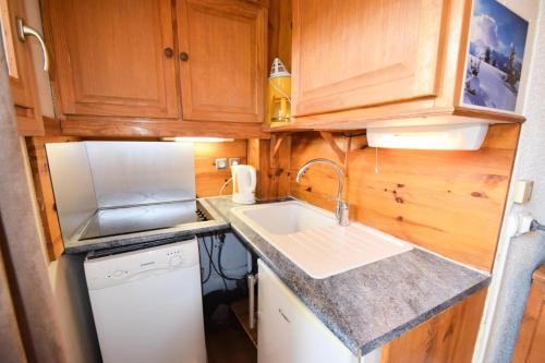 une petite cuisine avec un évier et un micro-ondes dans l'établissement Résidence Les Hameaux I - Studio 3/4 pers - LES HAMEAUX 1 - PLAGNE VILLAGES MAE-6134, à Aime La Plagne
