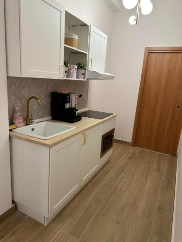 a kitchen with white cabinets and a sink at B&B Elegance in Villa San Giovanni
