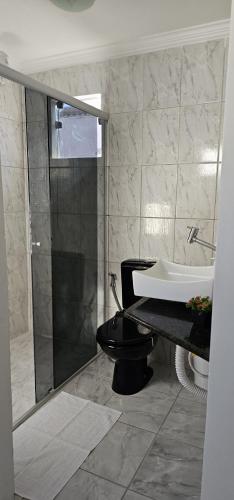 a bathroom with a shower and a toilet and a sink at Apartamento Praça da Bíblia in Bom Jesus da Lapa