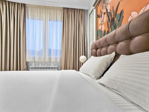 a bedroom with a large white bed and a window at Modern Harmony in Kolašin